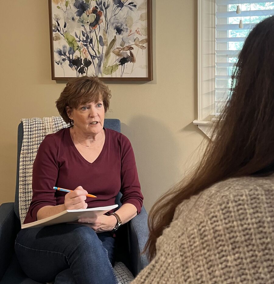 Ann taking notes during a counselling session with a client